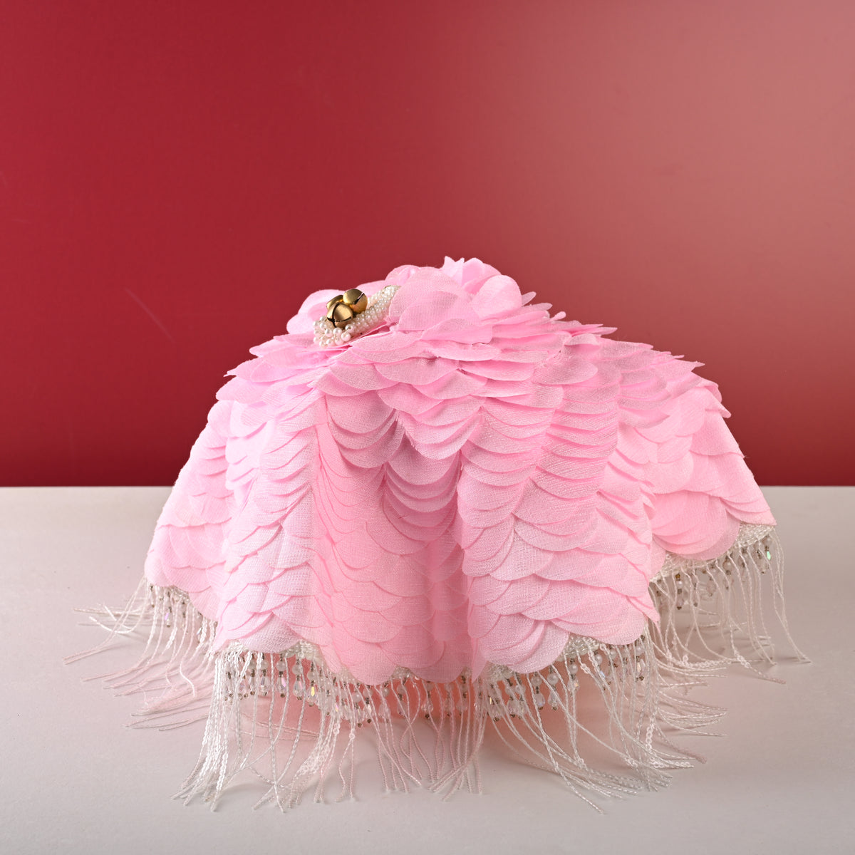 Pink thaal cover, front view on red backdrop